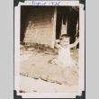 Baby sitting on blanket outside house (ddr-densho-483-571)