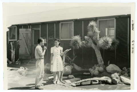 Photograph of Queen Margie Shimizu in front of a barracks garden (ddr-csujad-47-3)