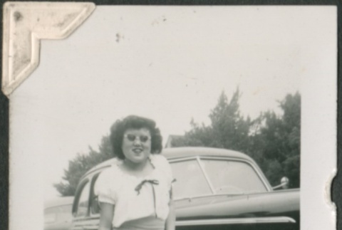 Young woman leaning on a car (ddr-densho-321-214)