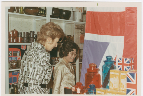 Tomoye Takahashi with unknown woman by British themed product display (ddr-densho-426-1096)