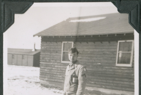Man standing in snow outside camp building (ddr-ajah-2-485)