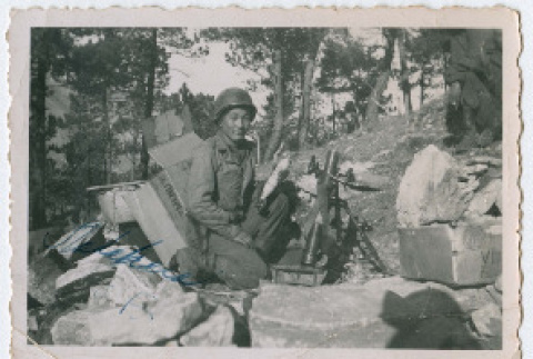 Soldier kneeling next to small artillery (ddr-densho-368-123)