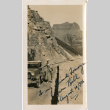Man standing next to car on rough road near mountains (ddr-densho-426-1480)