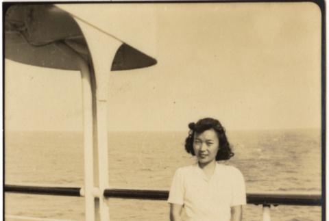 Woman standing by railing aboard ship (ddr-densho-426-1796)