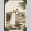 Woman and girl standing next to bench (ddr-densho-316-110)