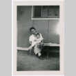 Woman holding baby outside barracks (ddr-densho-329-961)