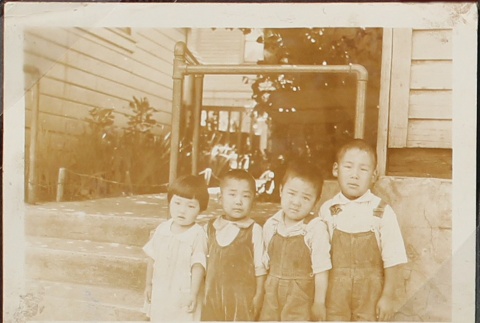 Four children lined up outside (ddr-densho-259-10)