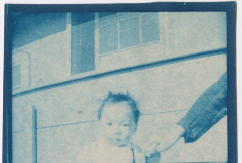 Baby standing outside barracks (ddr-densho-329-1333)