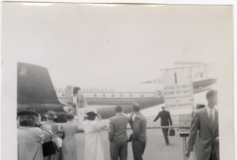 Group standing by fence at airport (ddr-densho-426-865)