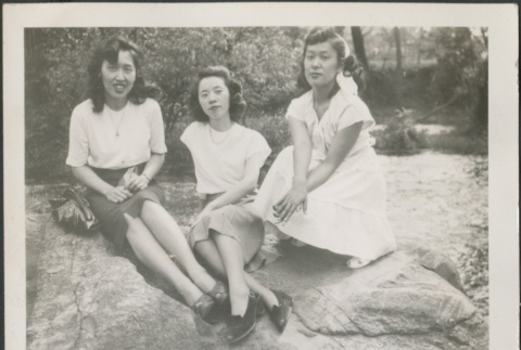 Three women sitting on a rock (ddr-densho-298-174)