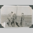 Four men standing on road talking (ddr-ajah-2-446)