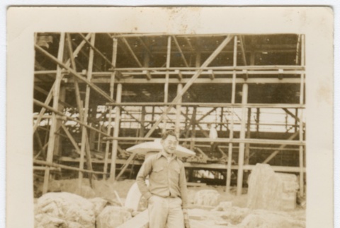 Photograph of an unknown man standing in front of a construction site (ddr-densho-329-285)