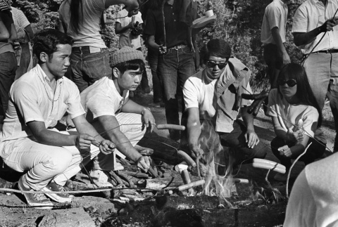 Campers roasting hot dogs during a hike up a mountain (ddr-densho-336-227)