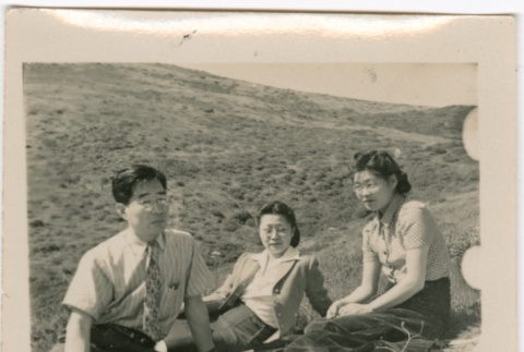 Henri Takahashi, Martha Nozawa, Tomoye Takahashi sitting on hillside (ddr-densho-426-1405)