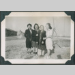 Four women in camp with barracks in background (ddr-densho-483-1099)