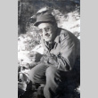 Shiro Robert Yamaguchi sitting in snow eating (ddr-densho-474-226)