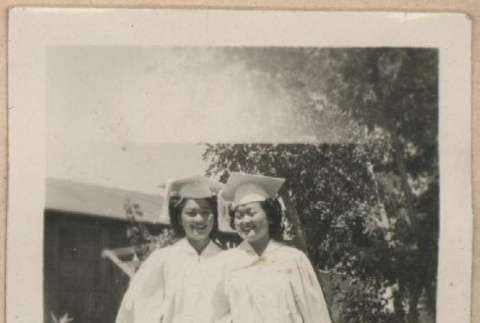 Two women wearing graduation caps and gowns (ddr-manz-10-65)