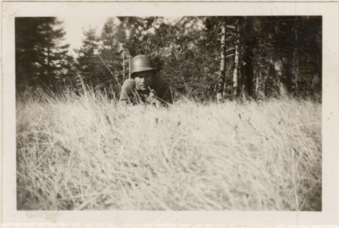One man laying down in tall grass (ddr-densho-466-265)