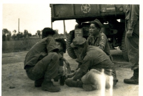 Soldiers sitting behind a truck (ddr-densho-22-238)