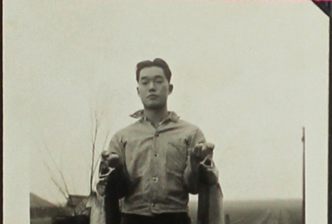 Man holding two steelhead trout (ddr-densho-201-323)