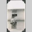 Man looking out window with sleeping bag hanging outside (ddr-ajah-2-158)