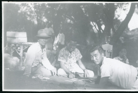 Photograph of people playing cards at a Manzanar hospital staff picnic (ddr-csujad-47-235)
