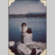 Color photo of two girls sitting by lake (ddr-densho-466-833)