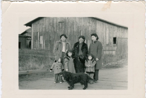Three women, three children and a dog outside barn (ddr-densho-523-687)
