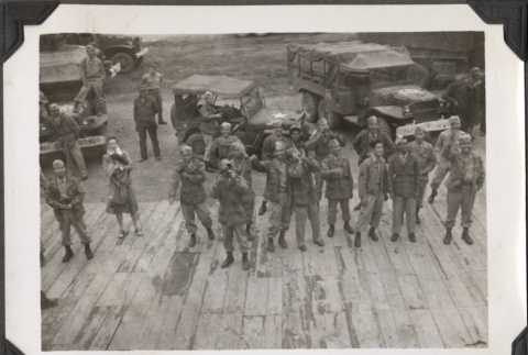 Group of men standing on dock looking up at ship (ddr-densho-466-155)