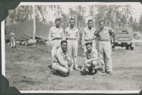 Six men posing for photo by tents (ddr-ajah-2-654)