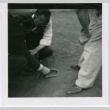 Men leaning over objects (ddr-densho-377-1647)
