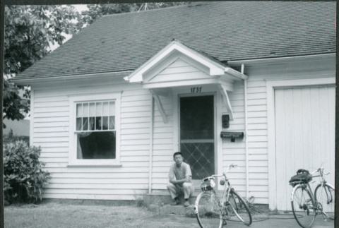 Man sitting on steps of house, with bicycles (ddr-densho-523-333)