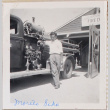 Man standing by fire truck outside fire station (ddr-densho-464-8)