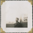Military man standing near large sign (ddr-densho-321-185)
