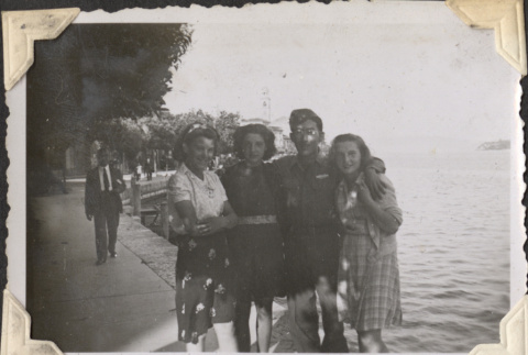 Man standing on walkway by lake with three women (ddr-densho-466-739)