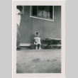 Little girl in bonnet outside barracks (ddr-densho-329-962)