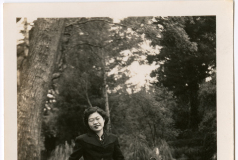 Tomoye Nozawa standing by metal fence (ddr-densho-423-482)