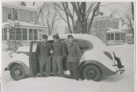 Three U.S. servicemen standing next to a car in the snow (ddr-densho-299-260)