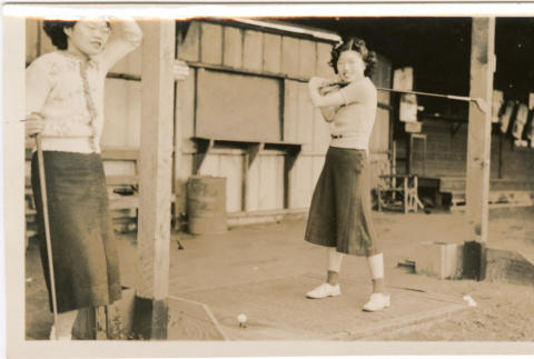 Tomoye (Nozawa) Takahashi and Martha (Nozawa) Tsuchida Suzuki with gold clubs (ddr-densho-426-2192)