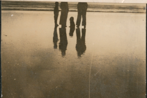 Family of four silhouetted on beach (ddr-densho-523-50)