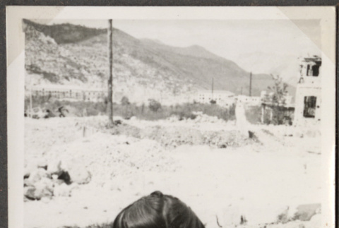 Woman standing with rubble in background (ddr-densho-466-103)
