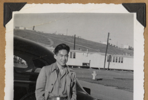 Gary Kikawa poses beside a car (ddr-densho-542-151)