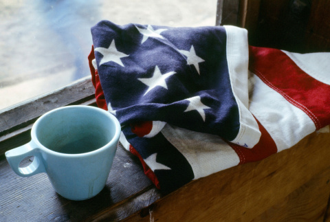 A folded American flag and mug (ddr-densho-336-1090)