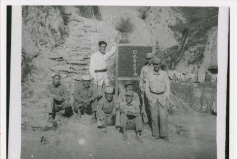 Eight servicepeople with sign (ddr-densho-1007-183)