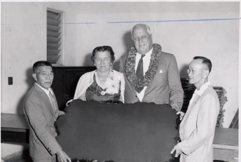 Hans L'Orange and wife holding up a table with two men (ddr-njpa-2-631)