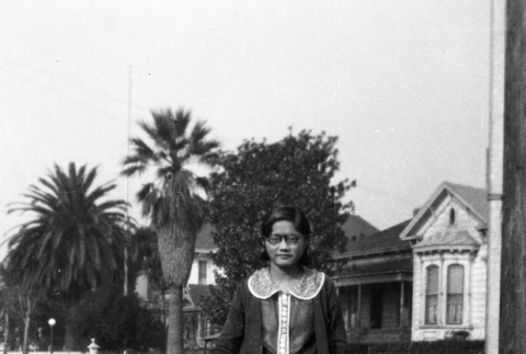 Marge Kajiwara standing on sidewalk carrying books (ddr-ajah-6-70)