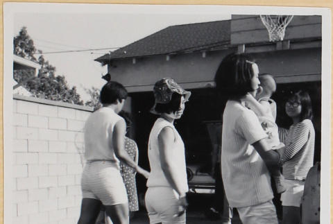 Group of girls, one holding a baby, in driveway (ddr-densho-522-89)