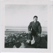 A serviceman sitting on a rocky beach (ddr-densho-338-17)