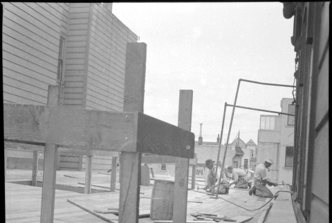 Men laying flooring on addition (ddr-densho-426-2164)