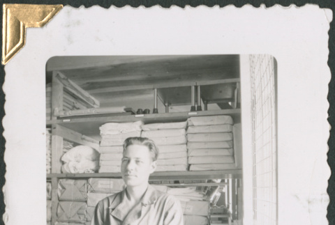 Man seated by supply shelves (ddr-densho-434-209)